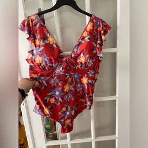 One piece V-neck bathing suit. Never worn. Still has liner. Ruffle shoulderstap.